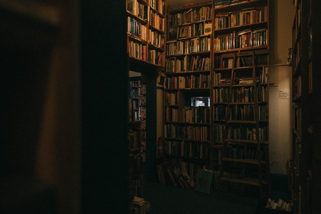 Old library with tall wooden shelves full of books under dim warm lighting