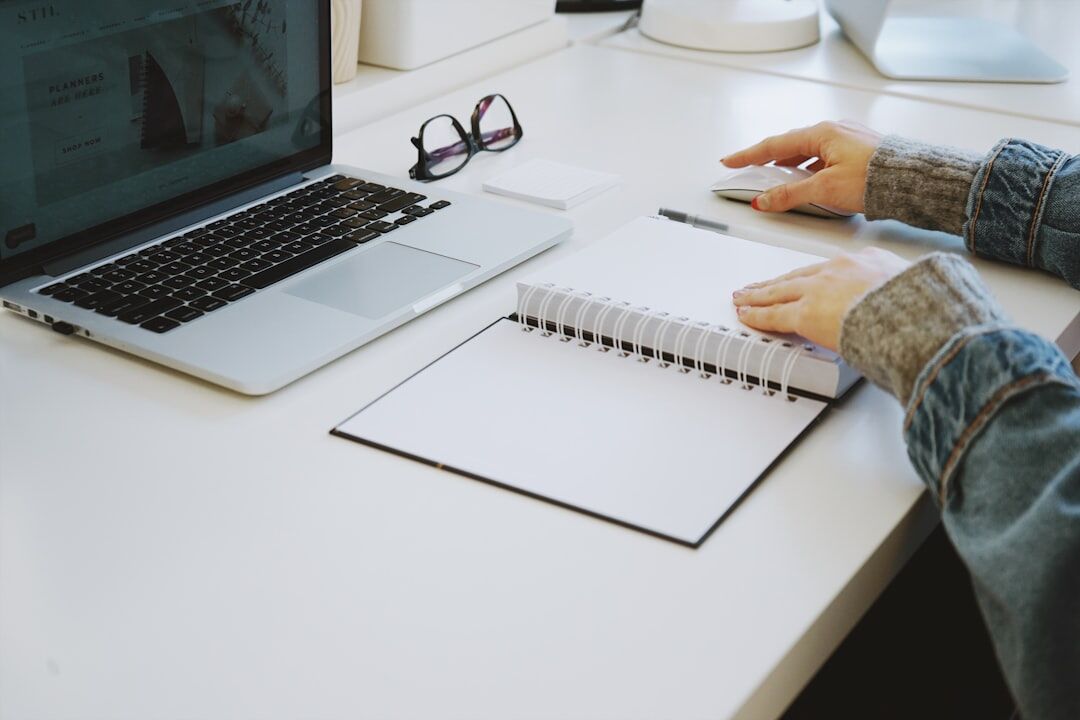 writer typing at desk with notebook